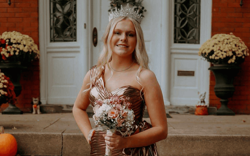 bride in a satin cocktail HOCO dress with flowers and a crown in her head